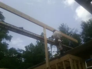 Carpenter setting a ridge beam over a new addition frame — Ice Dam Removal by Roofing Brothers in Lopez Island