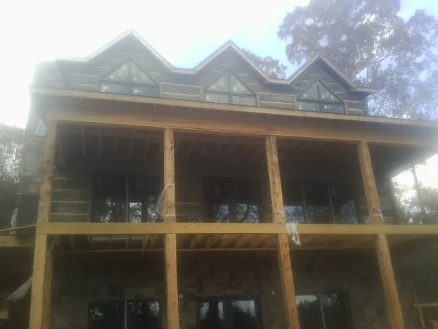 Dormers and porch framing on a large log home under construction — Roof Coating work by our crew in Lopez Island