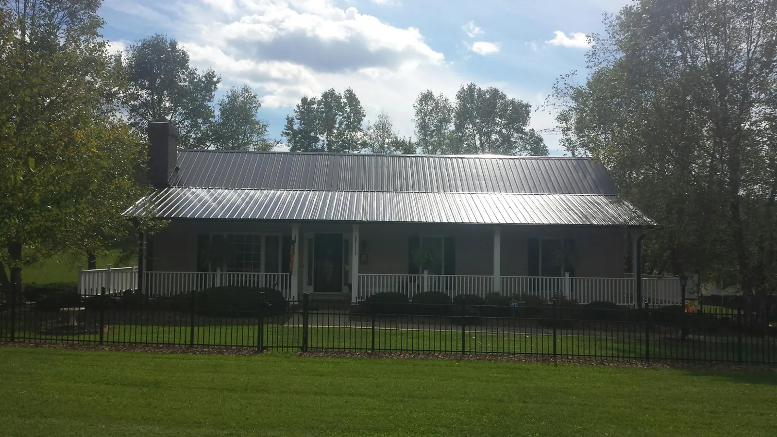 Gray metal roof on a brick ranch with a full width front porch — Gutter Guard Installation work by our crew in Lopez Island
