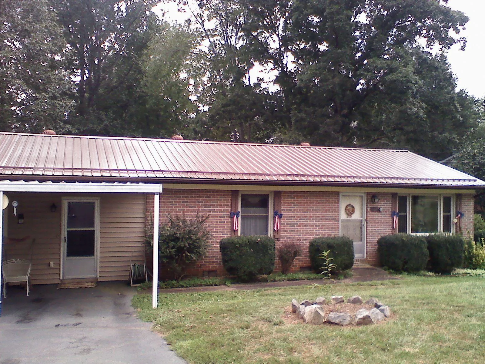 Bronze metal roof and carport on a brick ranch home — Roof Repair work by our crew in Lopez Island